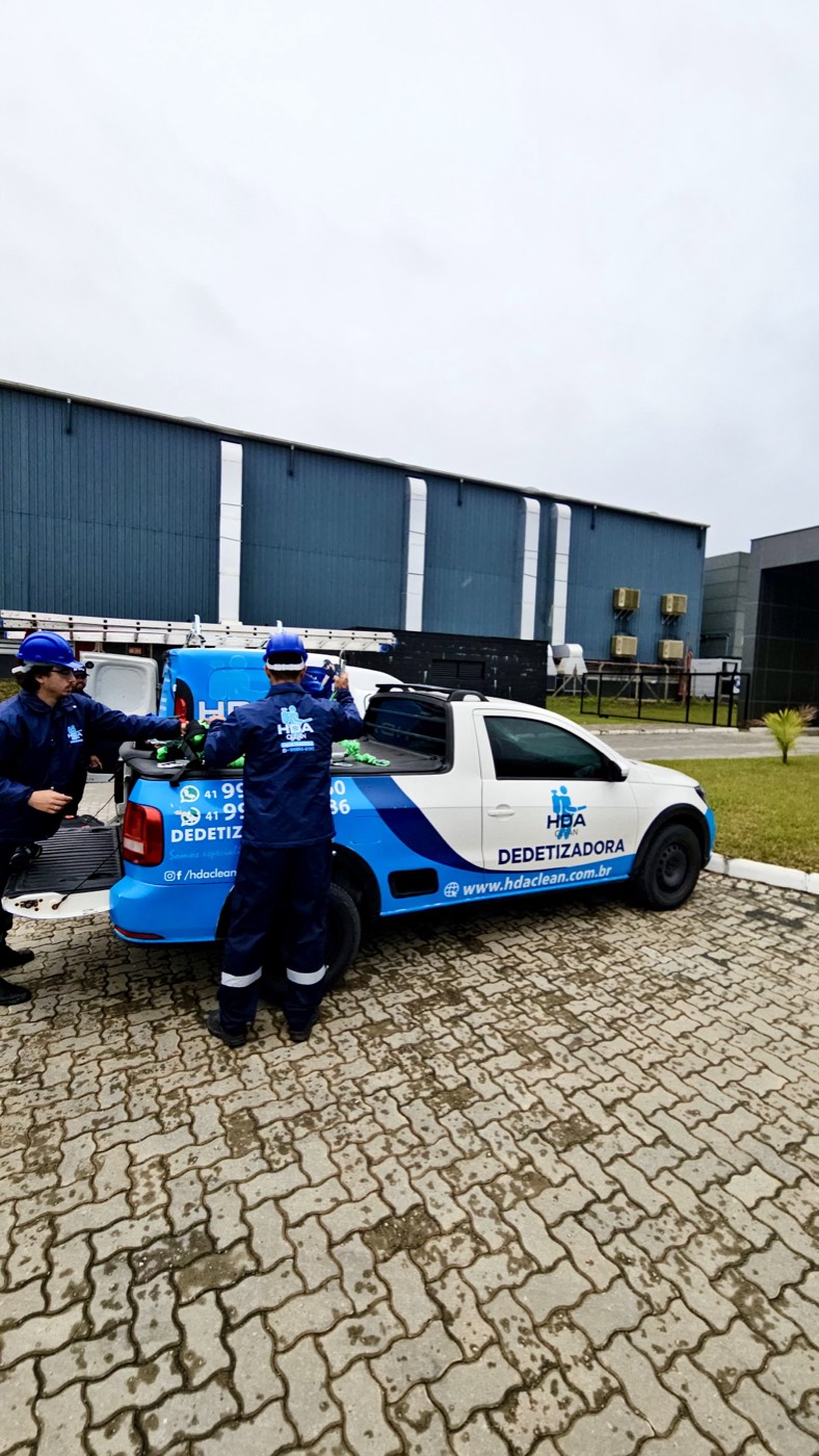 Técnicos da HDA Clean ao lado do veículo da empresa em atendimento